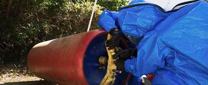 Two men in hazmat suits working with valve