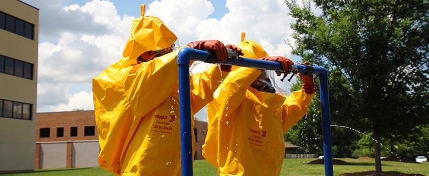 Two men in hazmat suits on metal bar